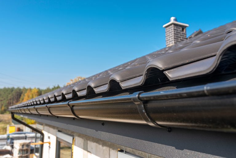 a metal black gutter on a roof covered with ceram 2026 01 09 01 07 09 utc